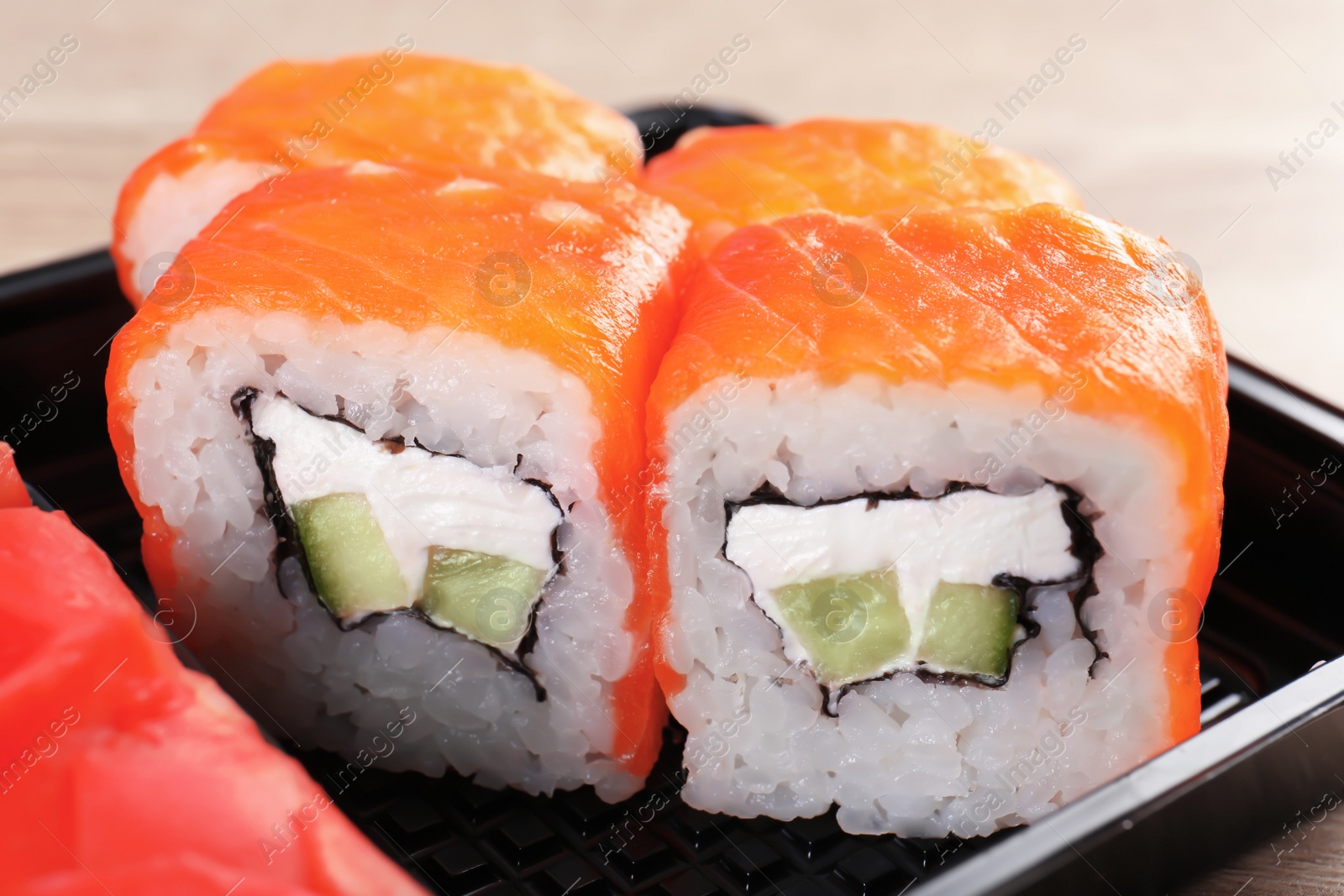 Photo of Box with tasty sushi rolls, closeup. Food delivery service