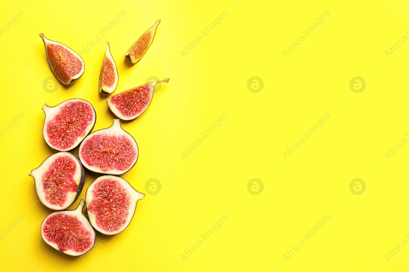 Photo of Cut ripe figs on color background, top view. Space for text