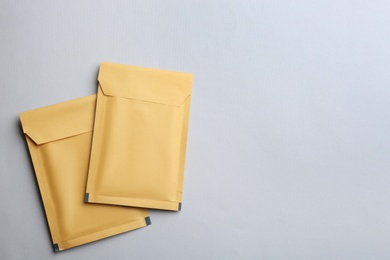 Kraft paper envelopes on light background, flat lay. Space for text