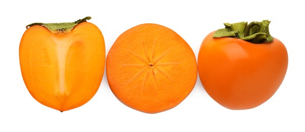 Photo of Whole and cut delicious ripe juicy persimmons on white background, top view