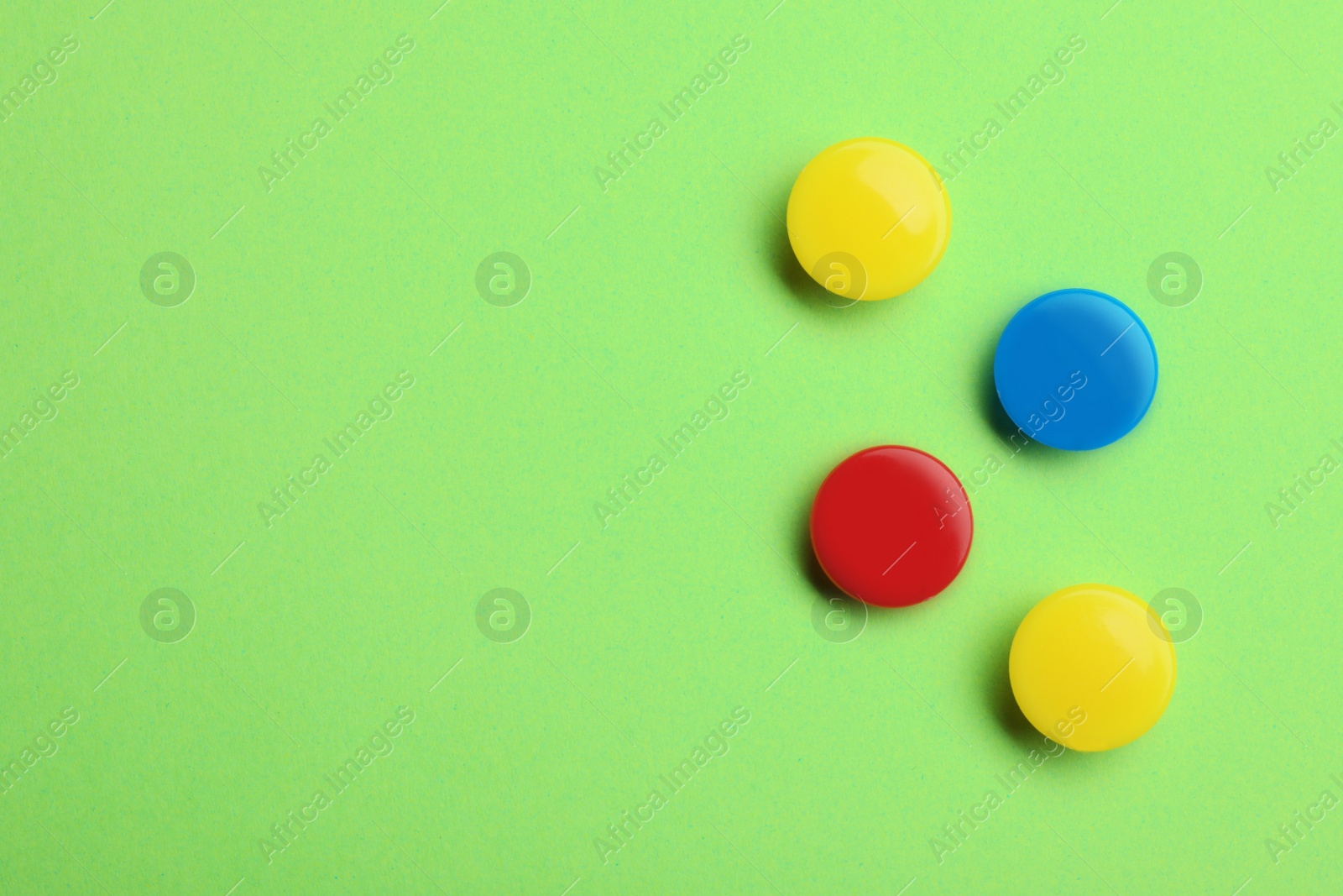 Photo of Bright magnets on color background, top view with space for text