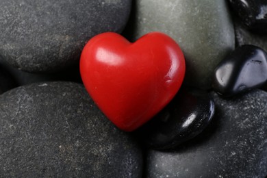 Red decorative heart on pebble stones, closeup