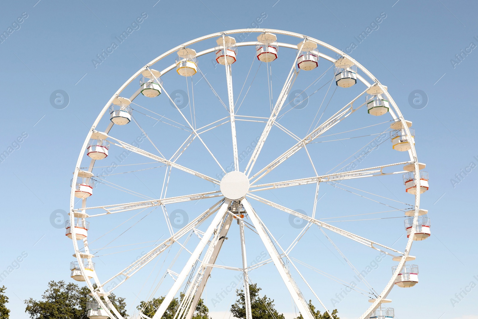 Photo of Beautiful white ferris wheel against blue sky