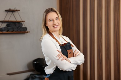 Photo of Portrait of professional hairdresser wearing apron in beauty salon