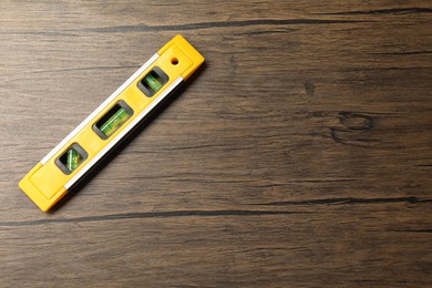 Building level on wooden table, top view. Space for text