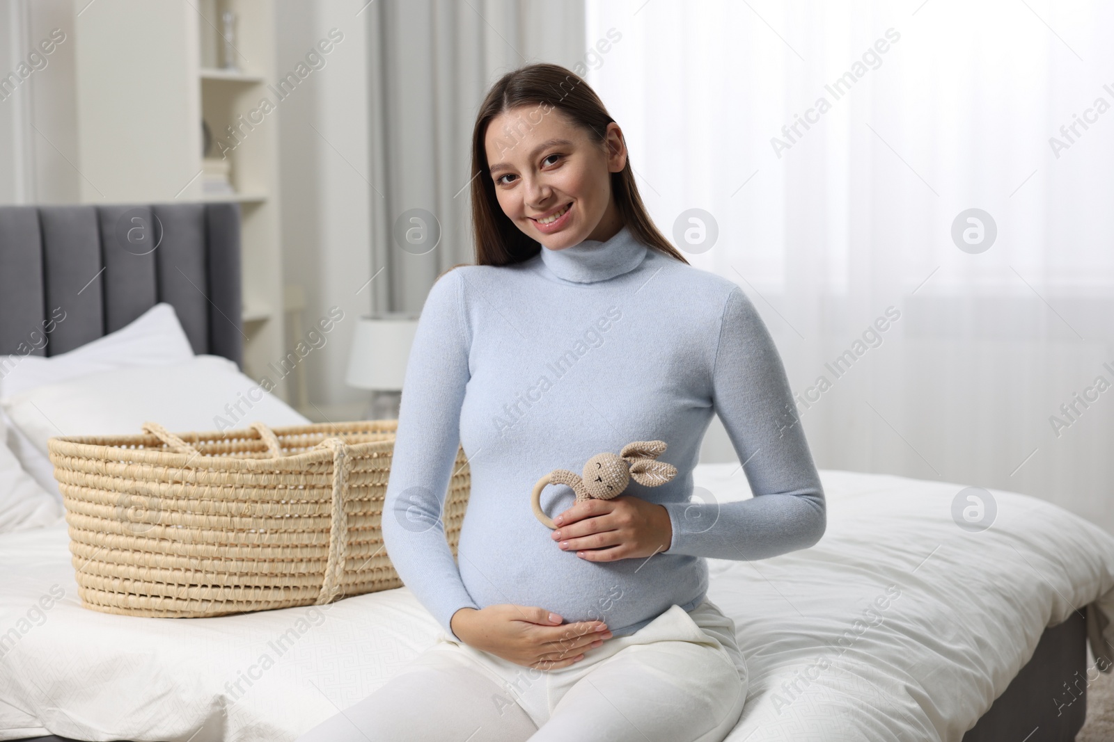 Photo of Beautiful pregnant woman with bunny toy in bedroom