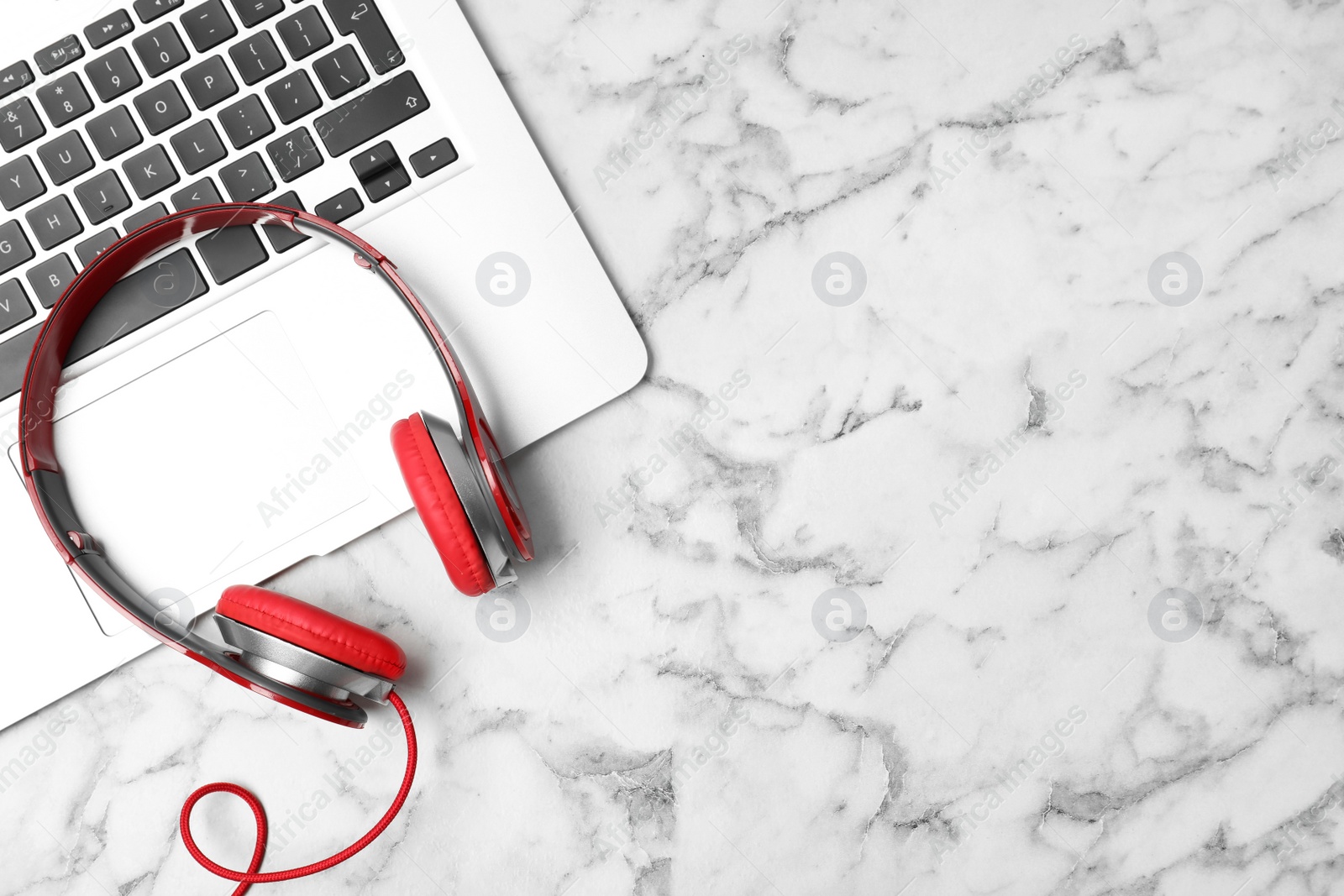 Photo of Flat lay composition with headphones, laptop and space for text on marble background