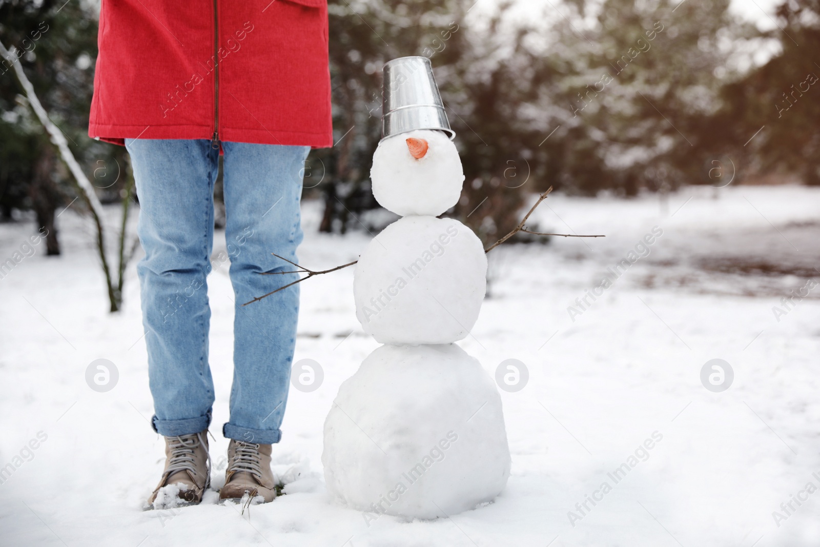 Photo of Young woman near snowman outdoors on winter day, closeup. Space for text