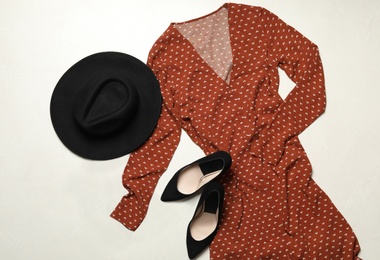 Flat lay composition with stylish red dress on light stone table