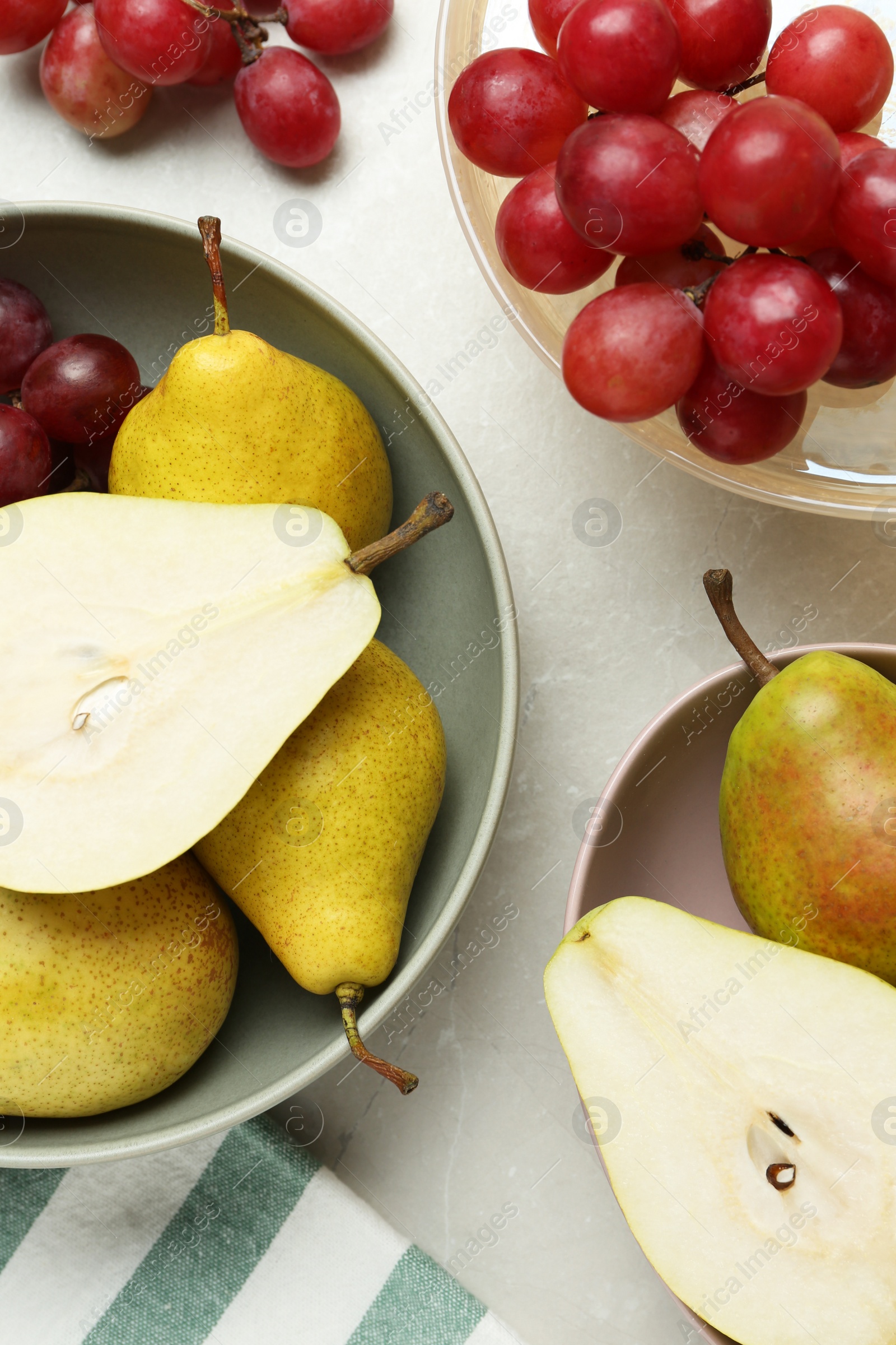 Photo of Fresh ripe pears and grapes on light grey table, flat lay