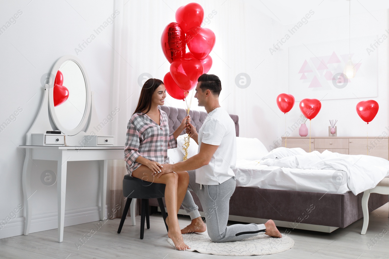 Photo of Beautiful couple with heart shaped balloons in bedroom