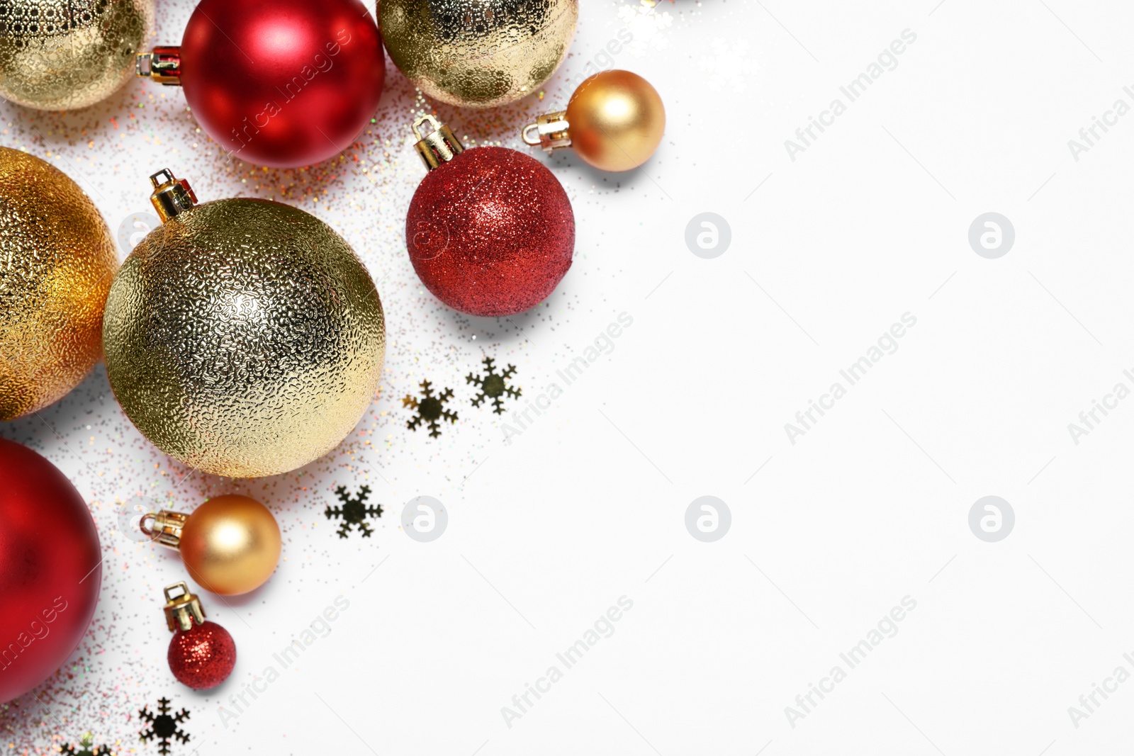Photo of Christmas balls, confetti and glitter on white background, flat lay. Space for text
