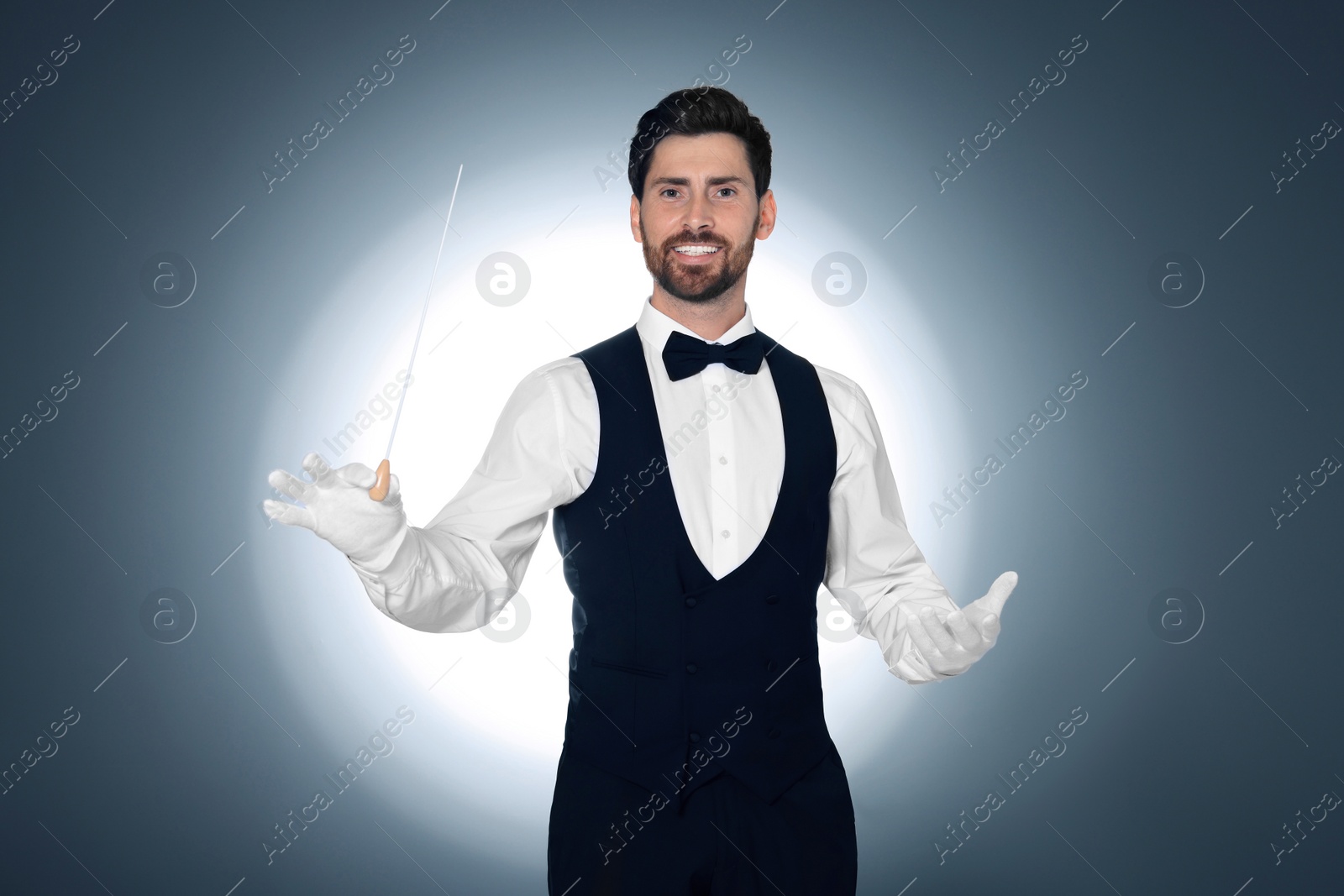 Photo of Happy professional conductor with baton on grey background