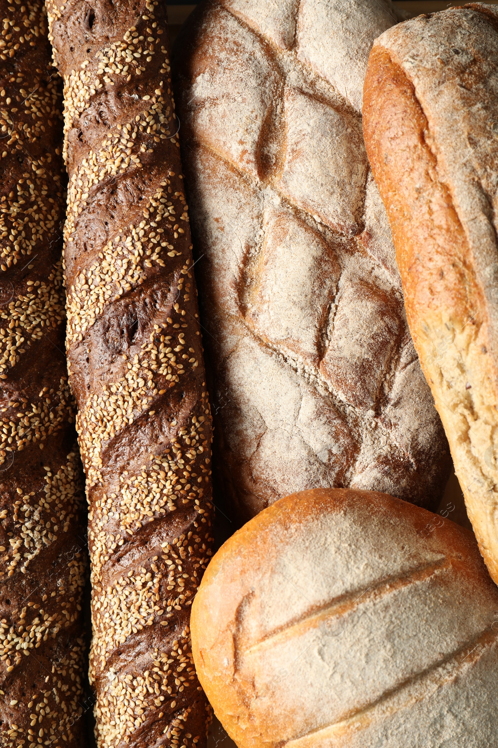 Photo of Different types of fresh bread as background, top view