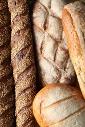 Different types of fresh bread as background, top view