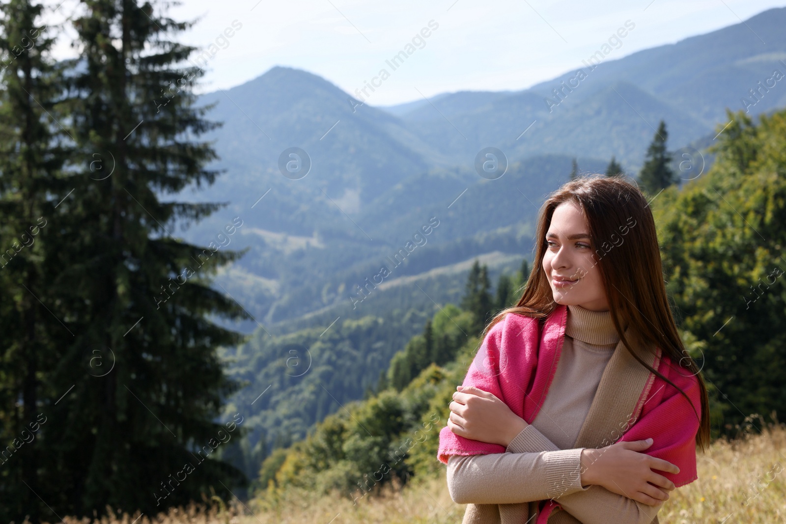 Photo of Young woman in mountains on sunny day, space for text