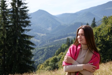 Photo of Young woman in mountains on sunny day, space for text