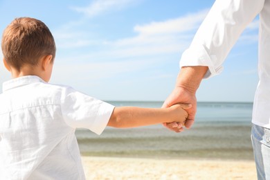 Little boy with grandfather on sea beach, closeup