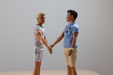 Leiden, Netherlands - September 20, 2023: Stylish Ken dolls handshaking on light gray background