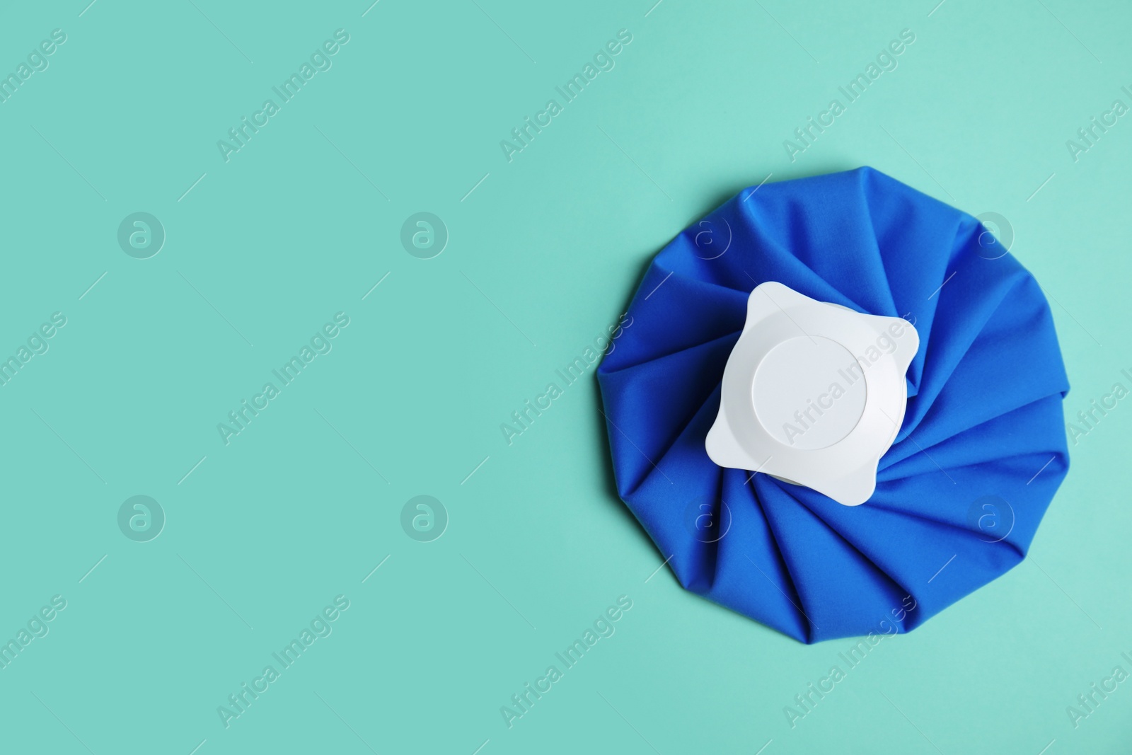 Photo of Ice pack on turquoise background, top view. Space for text