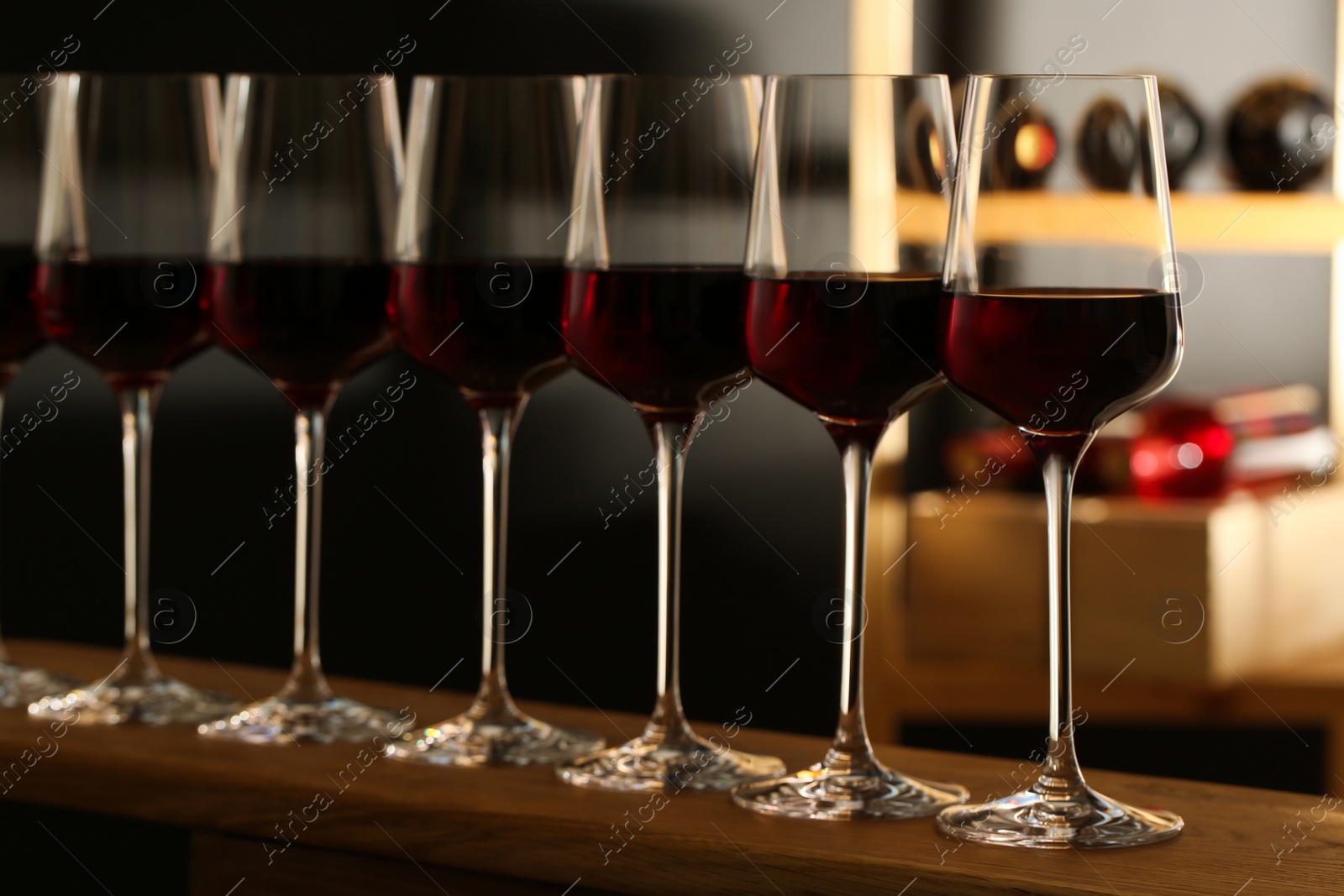 Photo of Glasses of red wine in cellar. Expensive drink