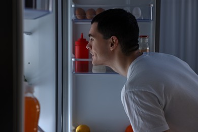 Photo of Happy man near refrigerator in kitchen at home