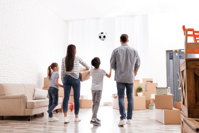Photo of Family in room with cardboard boxes on moving day