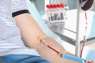 Photo of Man making blood donation at hospital, closeup