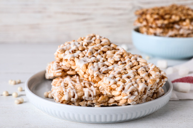 Photo of Delicious rice crispy treats on white wooden table, closeup