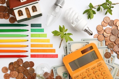 Photo of Flat lay composition with colorful chart and calculator on white background. Energy efficiency concept