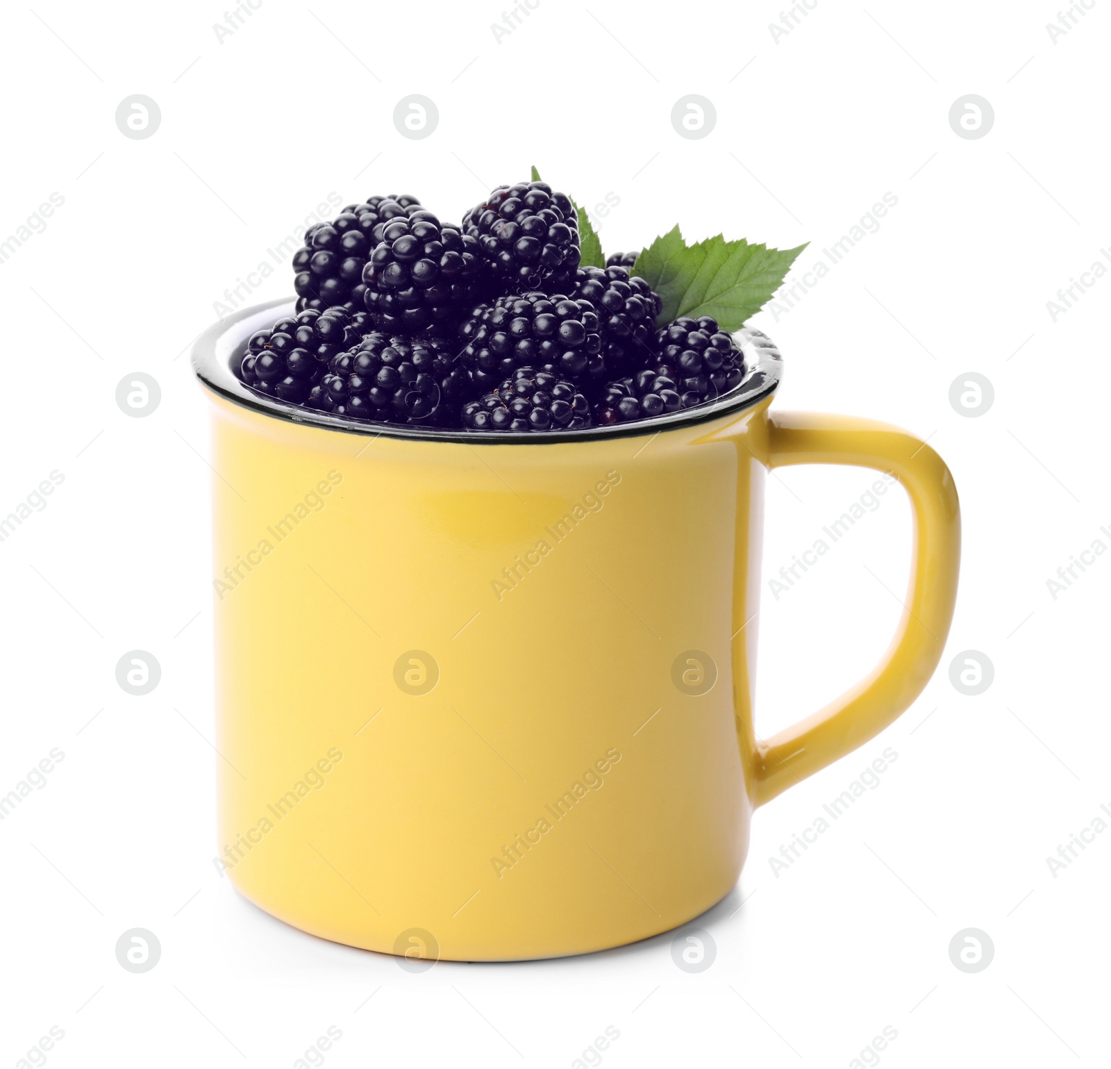 Photo of Yellow metal cup of tasty blackberries with leaves on white background