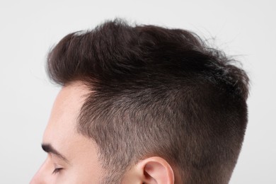 Man with healthy hair on light grey background, closeup