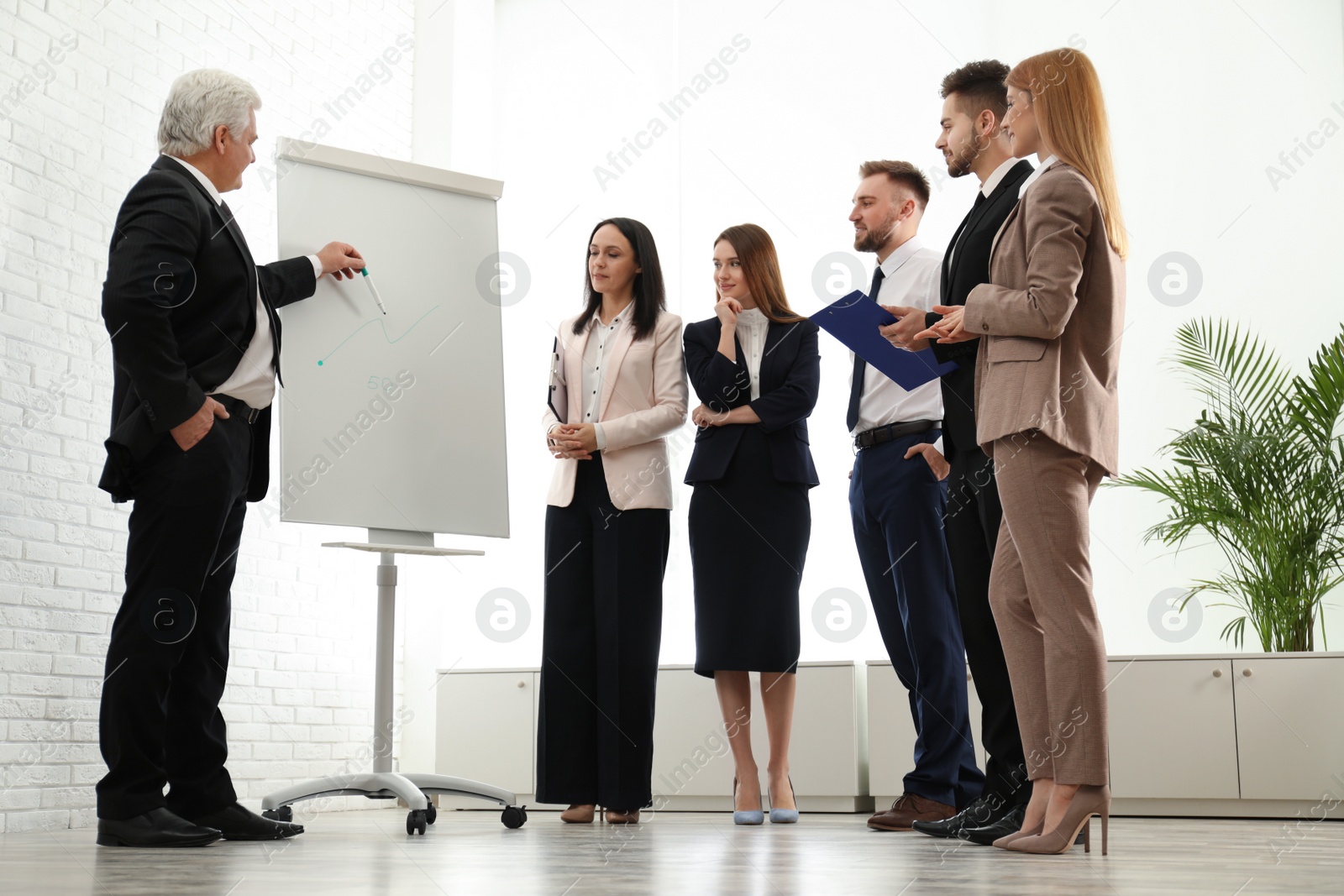 Photo of Senior business trainer working with people in office