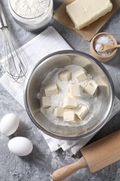 Making shortcrust pastry. Whisk, rolling pin and different ingredients for dough on grey table, flat lay