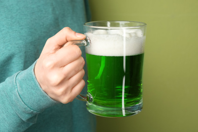 Photo of Woman with green beer on color background, closeup. St. Patrick's Day celebration