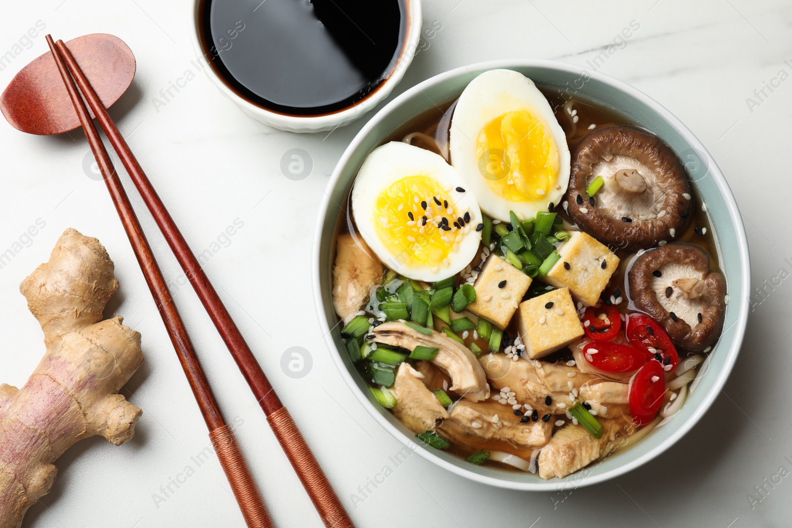 Photo of Delicious ramen served on white table, flat lay. Noodle soup