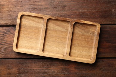 Photo of New compartment tray on wooden table, top view