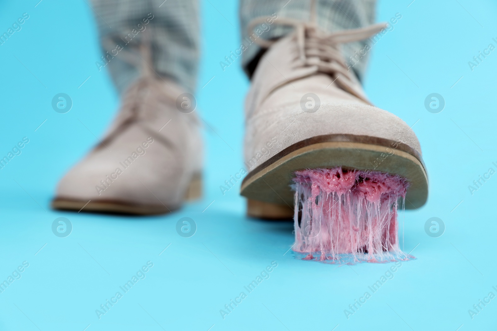 Photo of Person stepping into chewing gum on light blue background, closeup