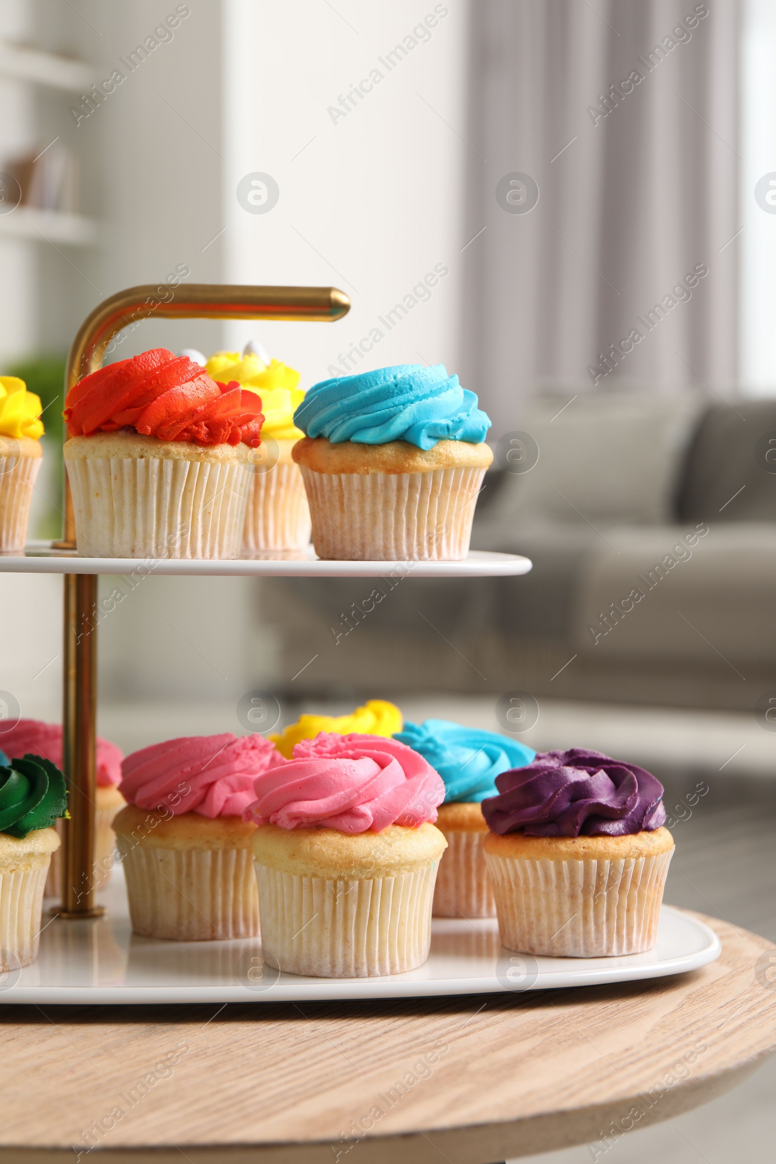 Photo of Delicious cupcakes with bright cream on wooden table indoors