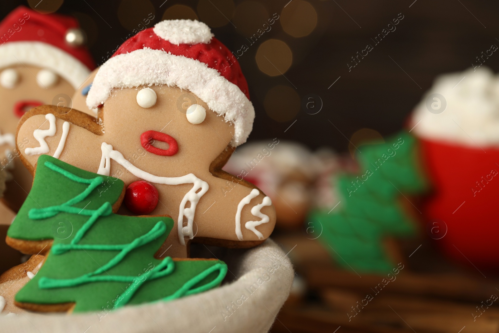 Photo of Delicious homemade Christmas cookies in bowl against blurred festive lights, closeup. Space for text