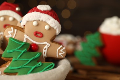 Photo of Delicious homemade Christmas cookies in bowl against blurred festive lights, closeup. Space for text