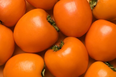 Photo of Delicious ripe juicy persimmons as background, closeup