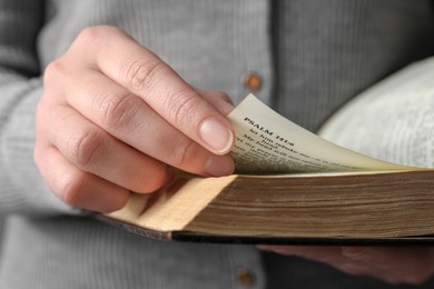 Photo of Woman reading old holy Bible, closeup view