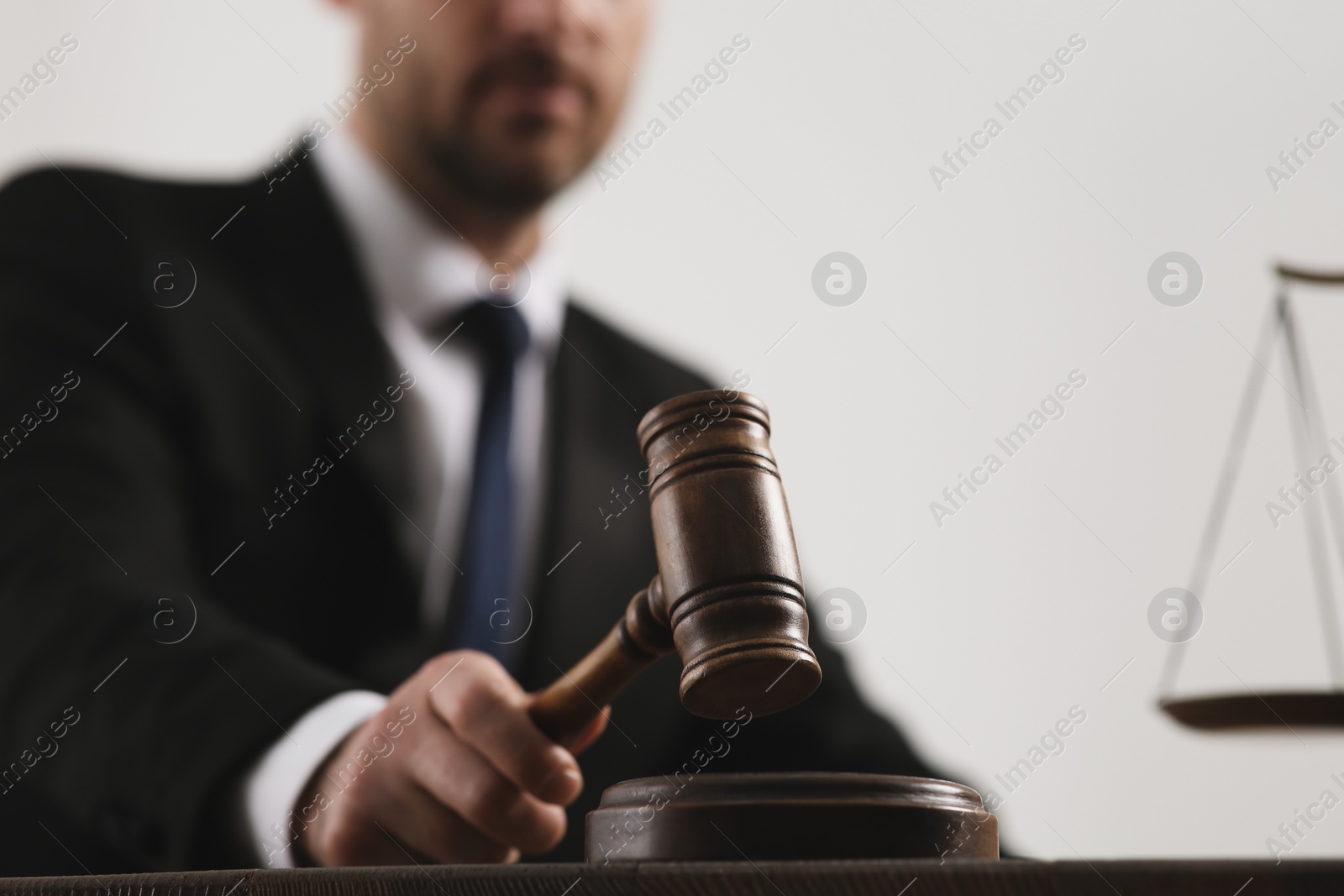 Photo of Law and justice. Closeup of judge with gavel at wooden table, selective focus