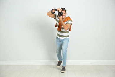 Photo of Professional photographer working near white wall in studio