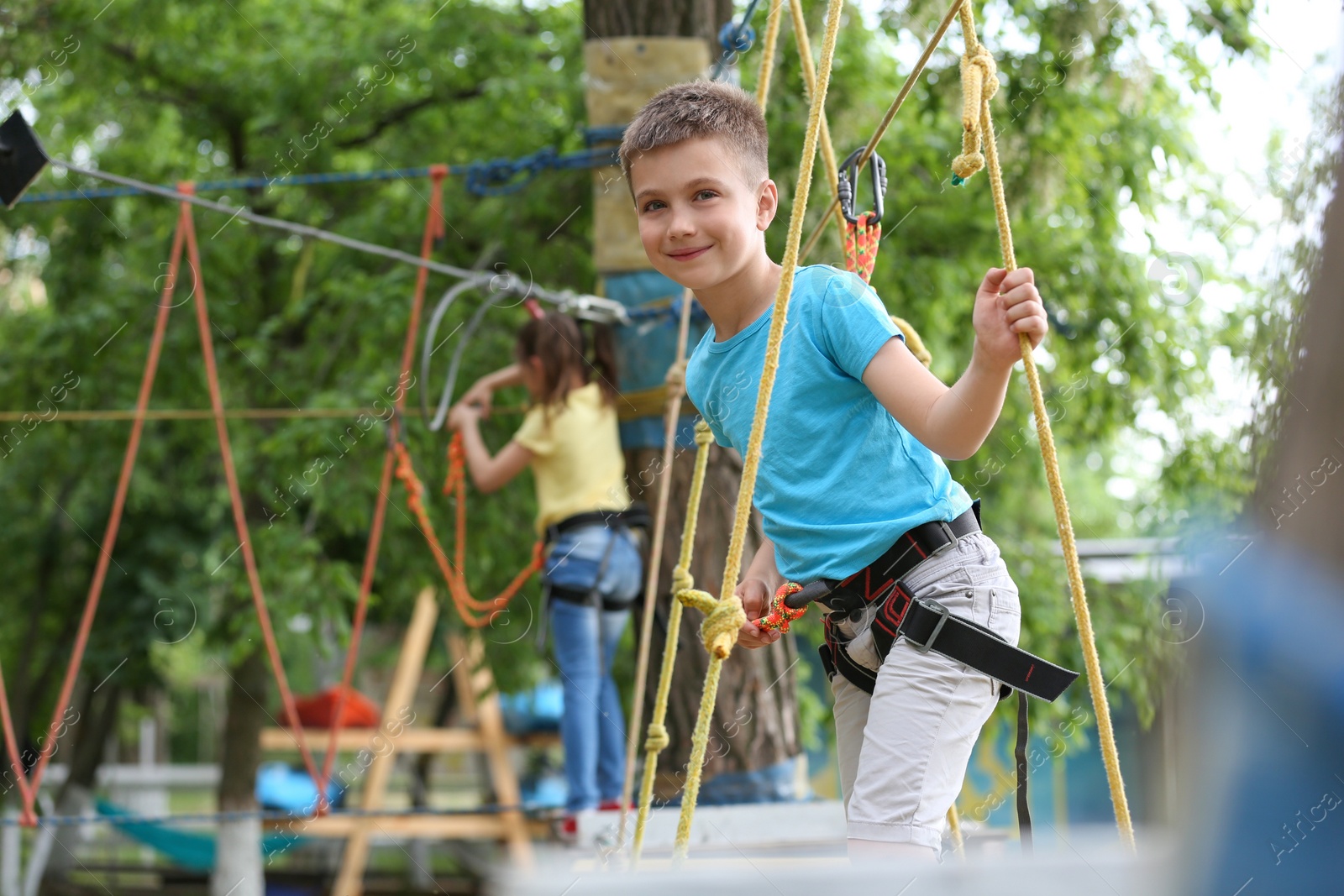 Photo of Little boy climbing in adventure park. Summer camp