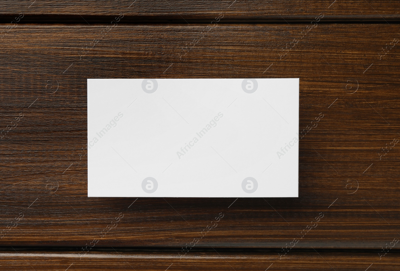 Photo of One blank business card on wooden table, top view. Mockup for design