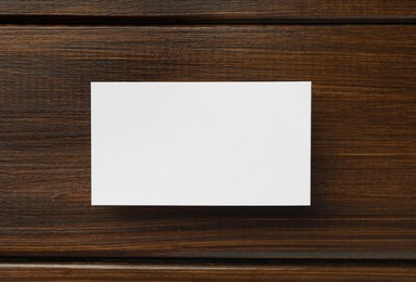 Photo of One blank business card on wooden table, top view. Mockup for design