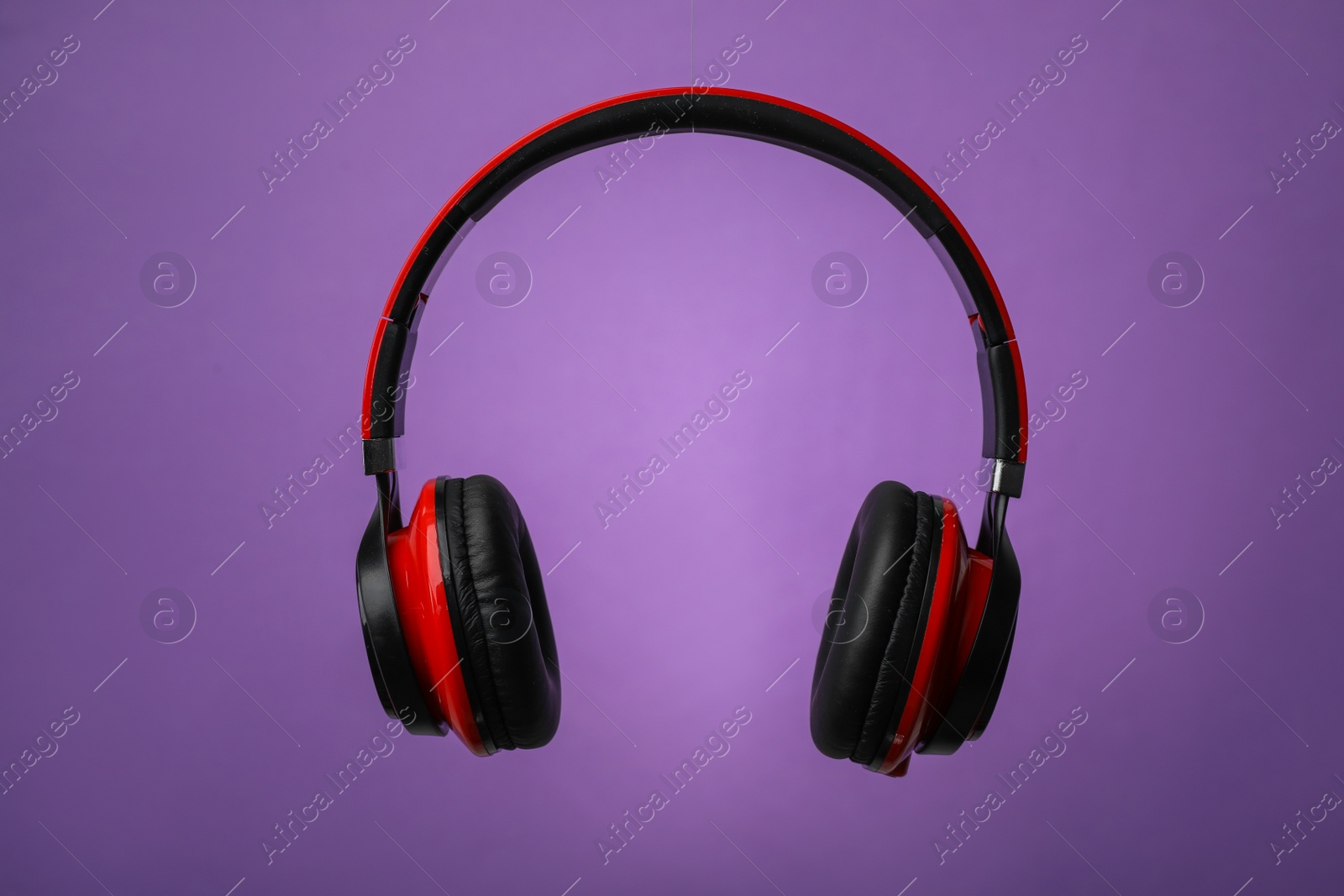 Photo of Wireless headphones with earmuffs on color background