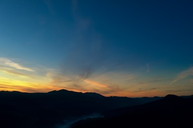 Image of Silhouette of mountain landscape at sunset . Drone photography